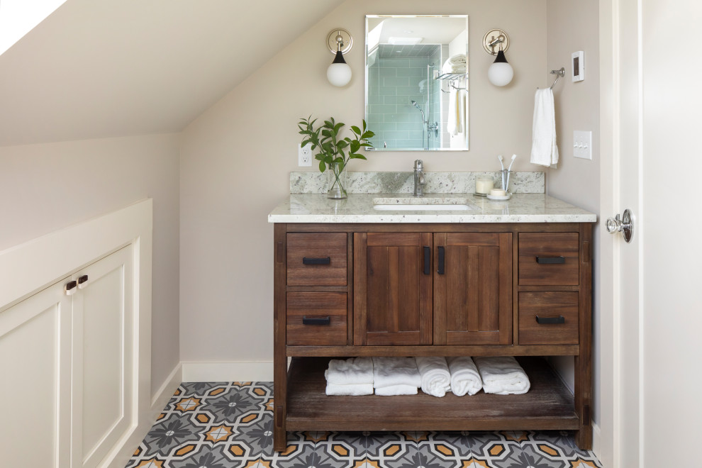 Imagen de cuarto de baño único y de pie clásico renovado de tamaño medio con armarios con paneles lisos, puertas de armario de madera oscura, ducha empotrada, sanitario de dos piezas, baldosas y/o azulejos grises, baldosas y/o azulejos de cerámica, paredes beige, suelo de baldosas de porcelana, aseo y ducha, lavabo bajoencimera, encimera de granito, suelo gris, ducha con puerta con bisagras, encimeras beige y hornacina