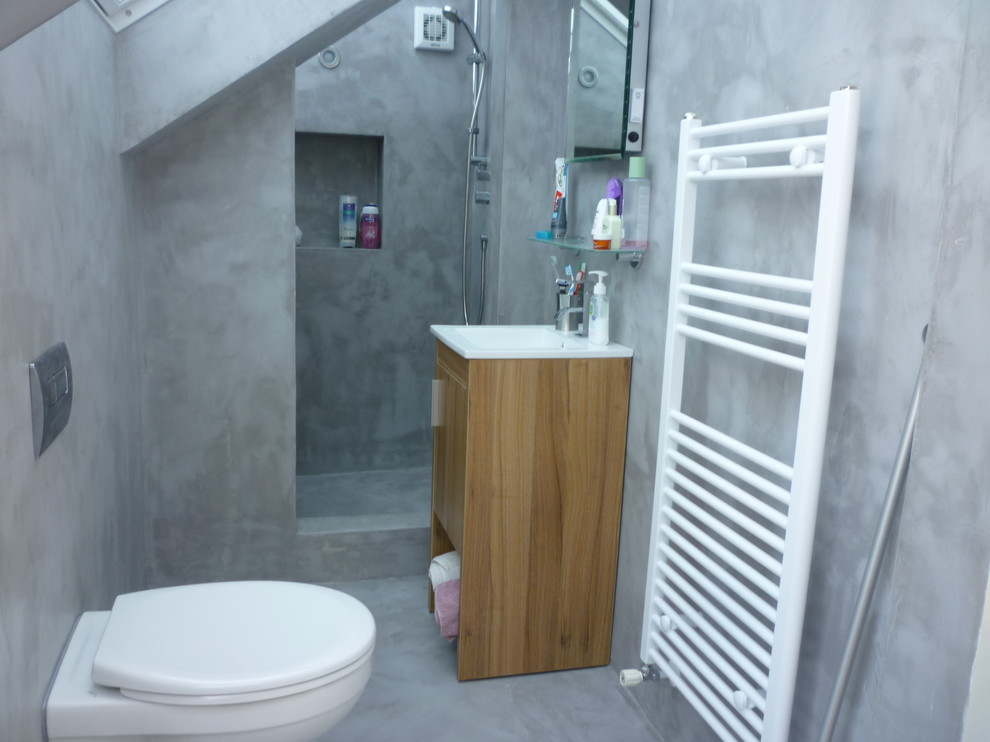 Small minimalist alcove shower photo in Dublin with a console sink, light wood cabinets, a wall-mount toilet and gray walls