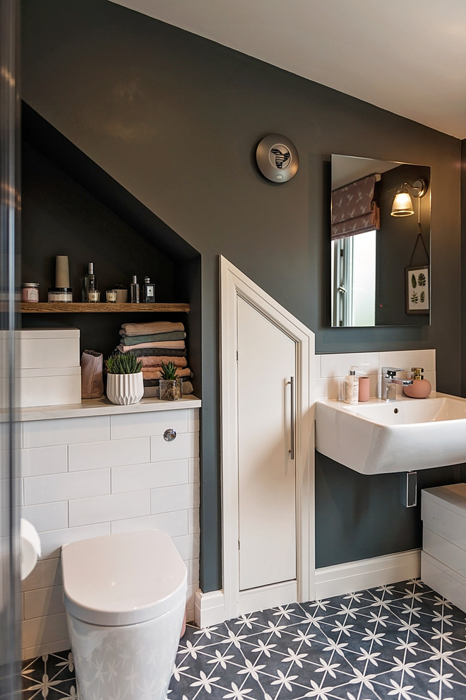 Exemple d'une petite salle de bain principale tendance avec un carrelage blanc, des carreaux de porcelaine, un mur gris, un sol en carrelage de porcelaine, un placard sans porte, WC à poser, un lavabo suspendu et un sol multicolore.