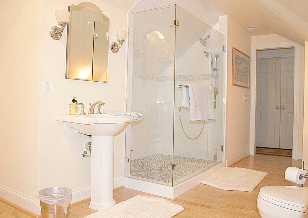 Foto på ett stort vintage badrum med dusch, med ett piedestal handfat, en öppen dusch, en toalettstol med hel cisternkåpa, grå kakel, keramikplattor, beige väggar och ljust trägolv