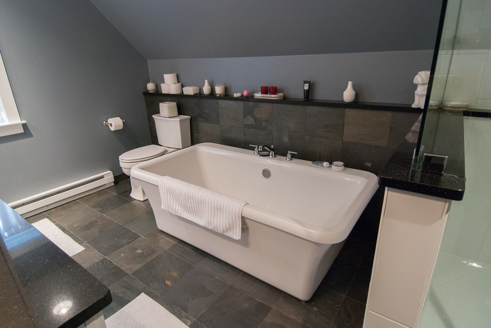 Пример оригинального дизайна: главная ванная комната среднего размера в современном стиле с фасадами с утопленной филенкой, белыми фасадами, отдельно стоящей ванной, угловым душем, белой плиткой, керамической плиткой, серыми стенами, полом из сланца, врезной раковиной и столешницей из искусственного кварца
