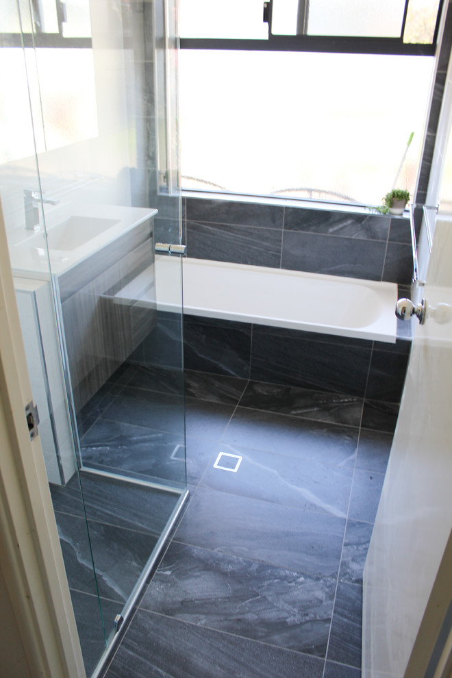 Inspiration for a small modern family bathroom in Perth with freestanding cabinets, brown cabinets, a built-in bath, a corner shower, white tiles, ceramic tiles, white walls, porcelain flooring, an integrated sink, solid surface worktops, black floors, a hinged door and yellow worktops.