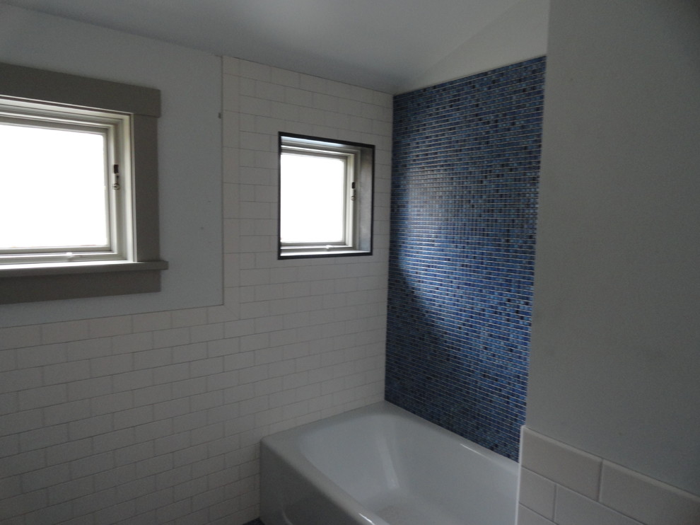 Foto på ett mellanstort vintage badrum med dusch, med släta luckor, skåp i mellenmörkt trä, ett badkar i en alkov, en dusch/badkar-kombination, en toalettstol med separat cisternkåpa, vit kakel, tunnelbanekakel, blå väggar, mosaikgolv, ett undermonterad handfat, bänkskiva i akrylsten och blått golv