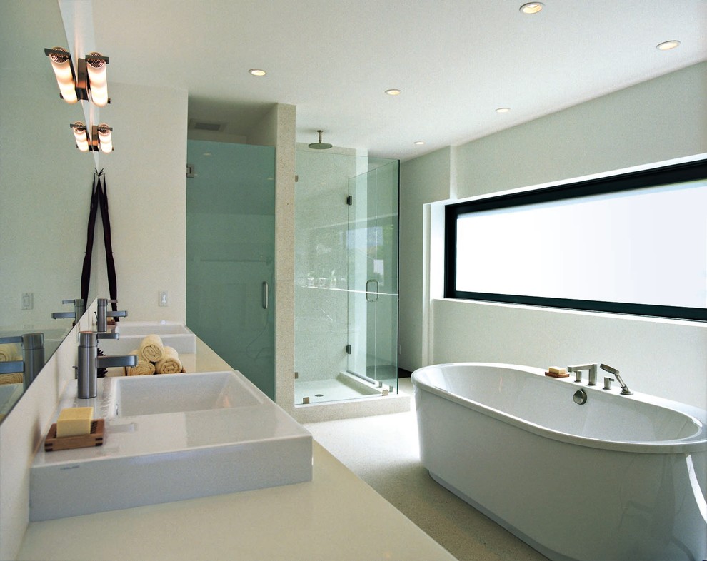 Diseño de cuarto de baño principal actual grande con bañera exenta, ducha esquinera, paredes blancas, suelo de cemento y lavabo sobreencimera