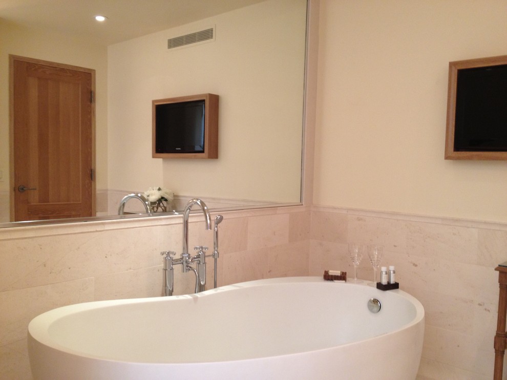 Foto de cuarto de baño contemporáneo con bañera exenta, baldosas y/o azulejos beige, baldosas y/o azulejos de piedra y paredes beige