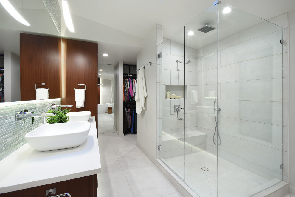 Пример оригинального дизайна: большая главная ванная комната в современном стиле с плоскими фасадами, темными деревянными фасадами, отдельно стоящей ванной, двойным душем, унитазом-моноблоком, белой плиткой, керамогранитной плиткой, белыми стенами, полом из керамогранита, настольной раковиной, столешницей из искусственного кварца, белым полом, душем с распашными дверями, белой столешницей, нишей, тумбой под две раковины, встроенной тумбой и деревянными стенами