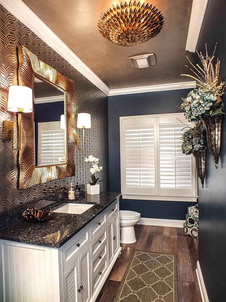 Inredning av ett modernt stort en-suite badrum, med ett nedsänkt handfat, luckor med infälld panel, vita skåp, granitbänkskiva, en toalettstol med hel cisternkåpa, blå väggar och mörkt trägolv