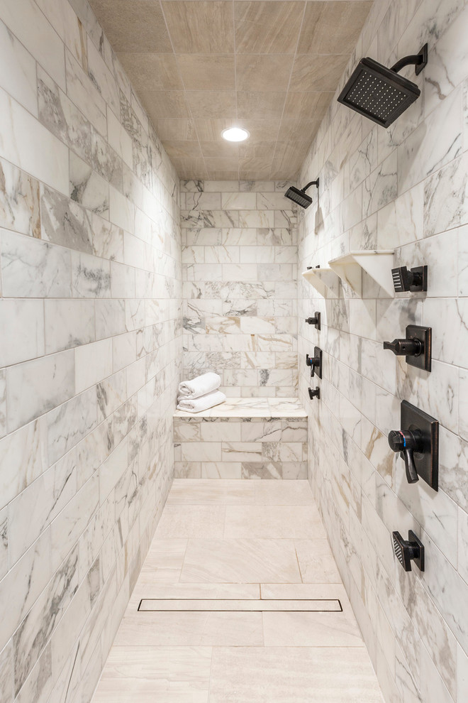 На фото: большая главная ванная комната в стиле неоклассика (современная классика) с отдельно стоящей ванной, двойным душем, серой плиткой, каменной плиткой, серыми стенами и полом из керамической плитки