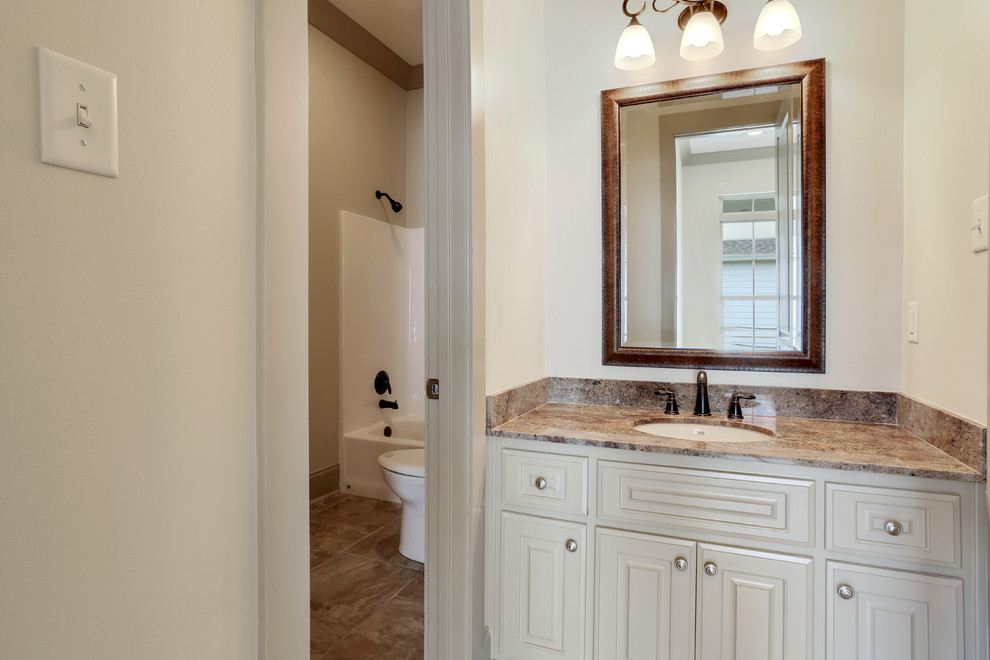 Idéer för ett mellanstort klassiskt badrum med dusch, med luckor med upphöjd panel, vita skåp, ett badkar i en alkov, en dusch/badkar-kombination, en toalettstol med hel cisternkåpa, vit kakel, tunnelbanekakel, vita väggar, travertin golv, ett undermonterad handfat och granitbänkskiva