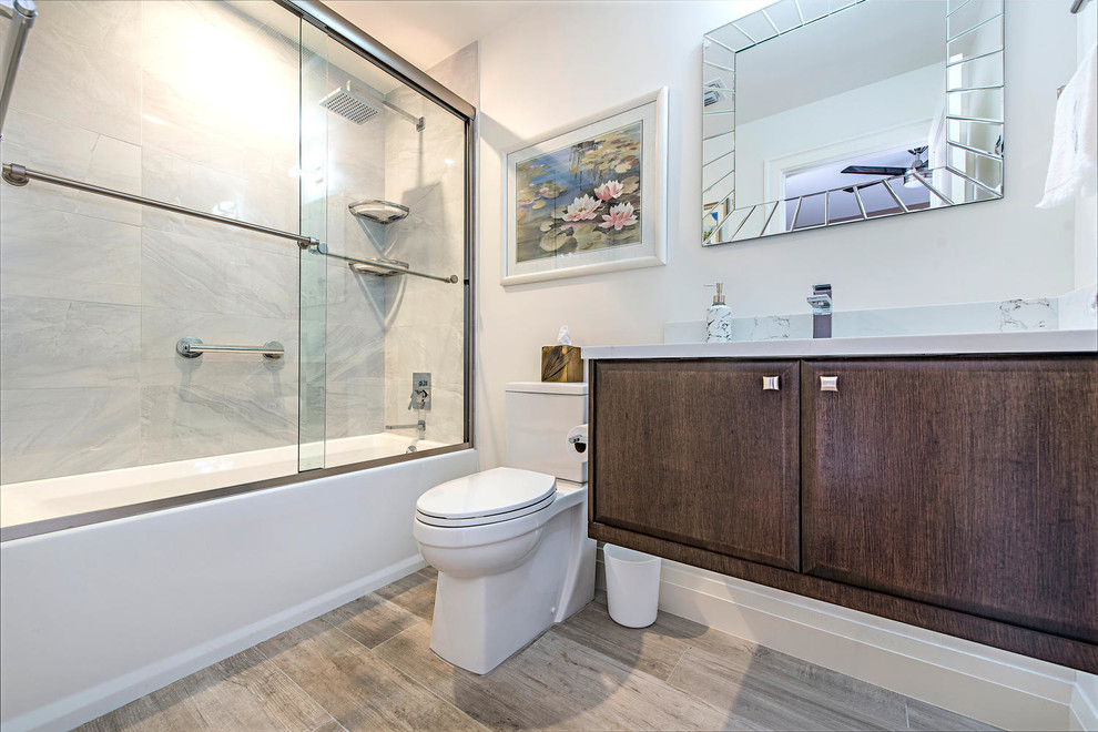 Inspiration for a mid-sized modern master light wood floor and beige floor bathroom remodel in Tampa with flat-panel cabinets, brown cabinets, a two-piece toilet, an undermount sink and quartz countertops