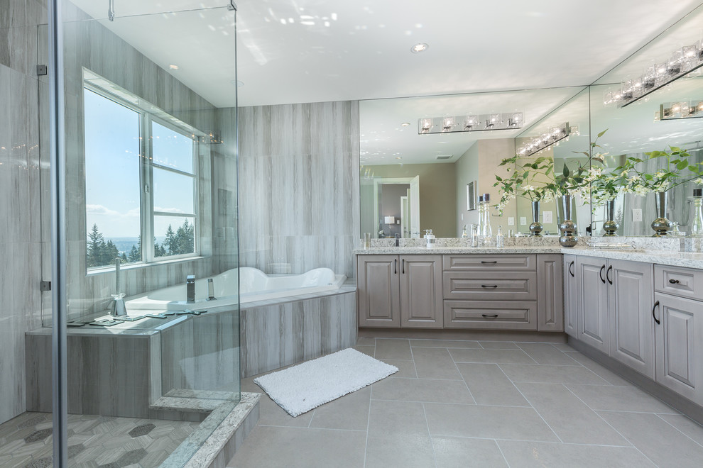 Cette image montre une salle de bain principale design avec une baignoire d'angle, une douche d'angle, un mur gris et un sol gris.