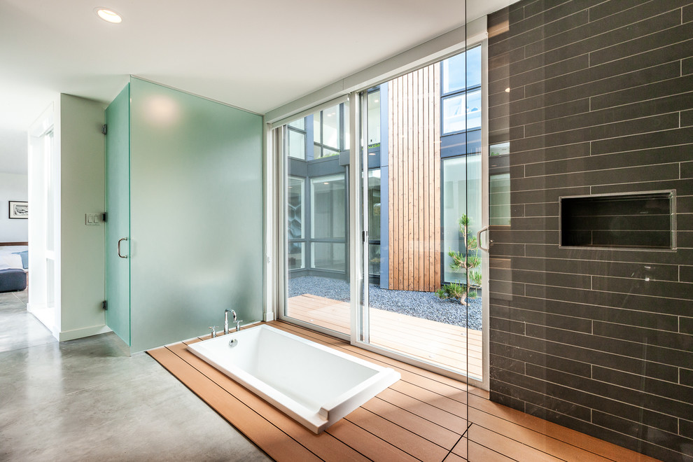 На фото: ванная комната в современном стиле с накладной ванной