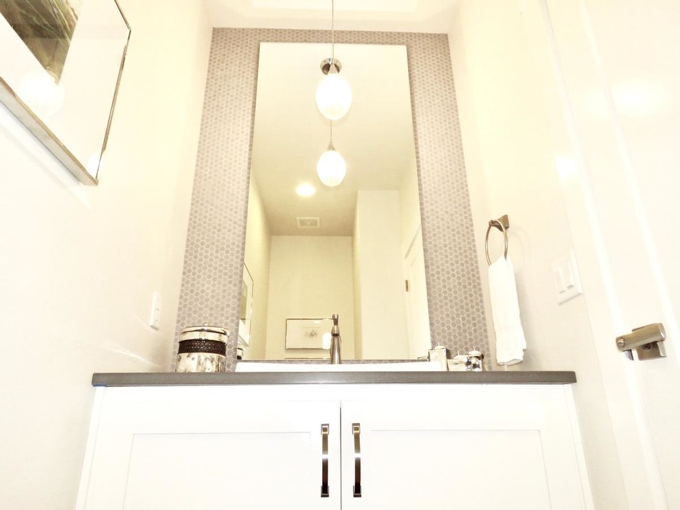 Esempio di una stanza da bagno chic di medie dimensioni con ante lisce, ante bianche, WC monopezzo, piastrelle di vetro, pareti bianche, top in quarzite, piastrelle beige e lavabo da incasso
