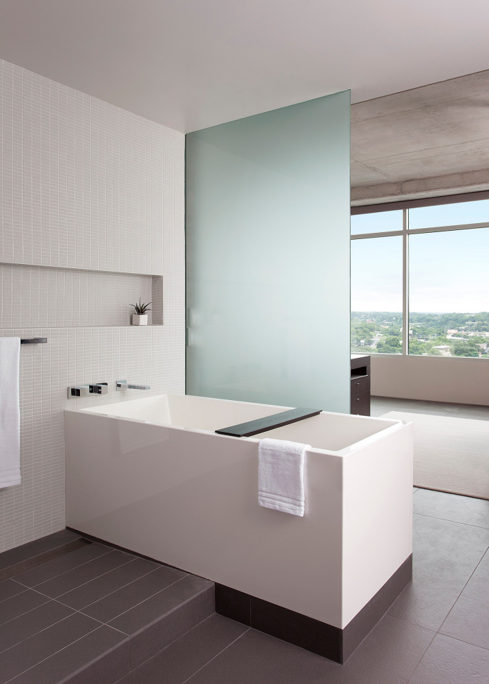 Modelo de cuarto de baño actual con bañera exenta, baldosas y/o azulejos blancos, baldosas y/o azulejos en mosaico y suelo gris