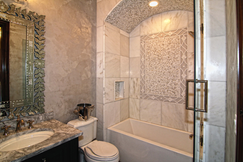 Design ideas for a large mediterranean family bathroom in Austin with freestanding cabinets, dark wood cabinets, an alcove bath, a shower/bath combination, a one-piece toilet, grey tiles, mosaic tiles, multi-coloured walls, porcelain flooring, a built-in sink, marble worktops, multi-coloured floors and a hinged door.