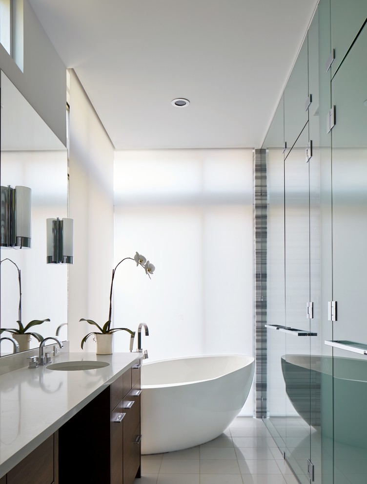 Inspiration för mellanstora moderna en-suite badrum, med släta luckor, skåp i mörkt trä, ett fristående badkar, en kantlös dusch, vit kakel, porslinskakel, vita väggar, klinkergolv i porslin, ett undermonterad handfat och bänkskiva i kvarts