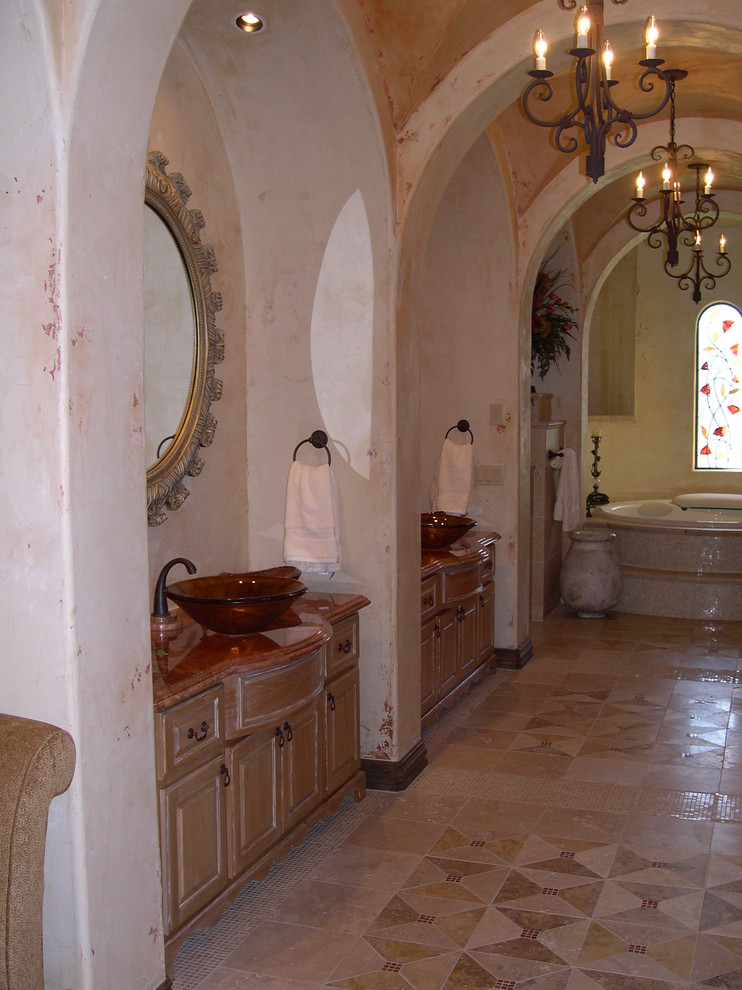 Réalisation d'une salle de bain principale méditerranéenne en bois clair de taille moyenne avec un placard avec porte à panneau surélevé, un carrelage beige, un carrelage de pierre, un mur blanc, une vasque et un plan de toilette en marbre.