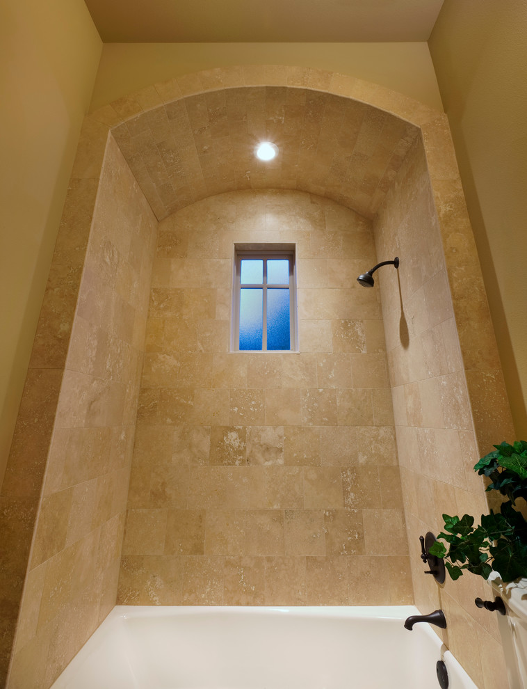 Aménagement d'une douche en alcôve classique pour enfant avec une baignoire en alcôve, un carrelage beige, un carrelage de pierre, un mur beige, un sol en travertin et un plan de toilette en carrelage.