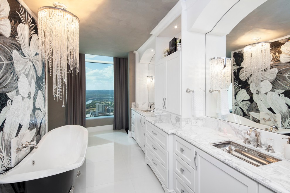 Cette photo montre une salle de bain principale chic avec un lavabo encastré, un placard à porte shaker, des portes de placard blanches, une baignoire sur pieds, un carrelage multicolore et un mur gris.