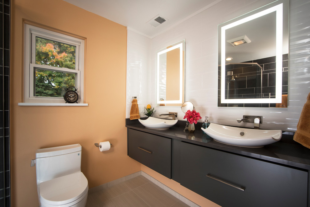 Modelo de cuarto de baño contemporáneo con armarios con paneles lisos, puertas de armario grises, baldosas y/o azulejos blancos, paredes amarillas y lavabo sobreencimera