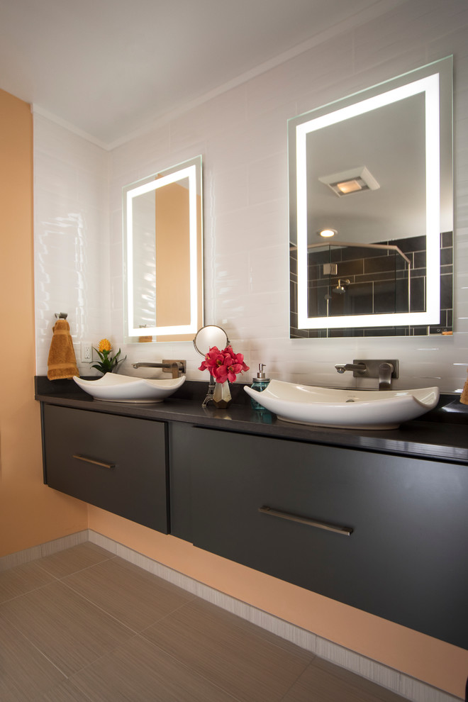 Ejemplo de cuarto de baño contemporáneo con armarios con paneles lisos, puertas de armario grises, baldosas y/o azulejos blancos, paredes amarillas y lavabo sobreencimera