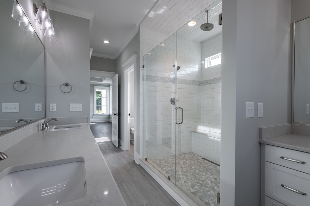 Foto på ett mellanstort lantligt vit en-suite badrum, med vita skåp, en dusch i en alkov, vit kakel, tunnelbanekakel, grå väggar, klinkergolv i porslin, ett undermonterad handfat, bänkskiva i kvartsit, grått golv och dusch med gångjärnsdörr