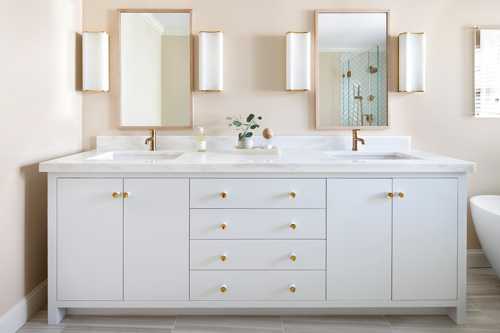 Immagine di una stanza da bagno padronale chic con ante bianche, pareti beige, pavimento con piastrelle in ceramica, lavabo sottopiano, top in marmo, ante lisce e pavimento beige