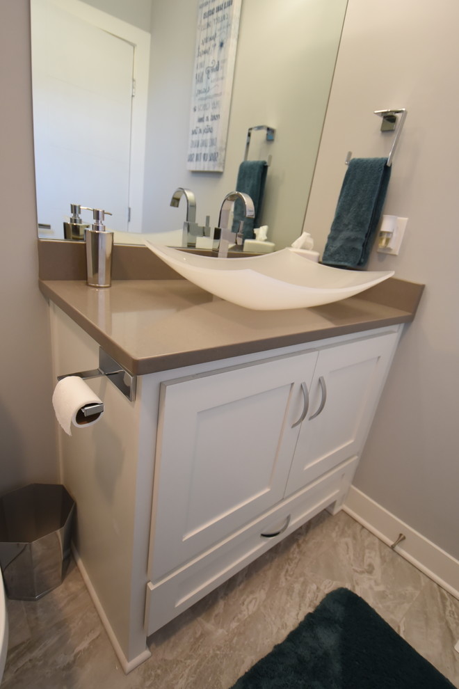 Cette photo montre une petite salle d'eau moderne avec un placard à porte shaker, des portes de placard blanches, WC séparés, un carrelage gris, des carreaux de céramique, un mur gris, un sol en carrelage de céramique, une vasque, un plan de toilette en quartz modifié, un sol gris, une cabine de douche à porte coulissante et un plan de toilette gris.