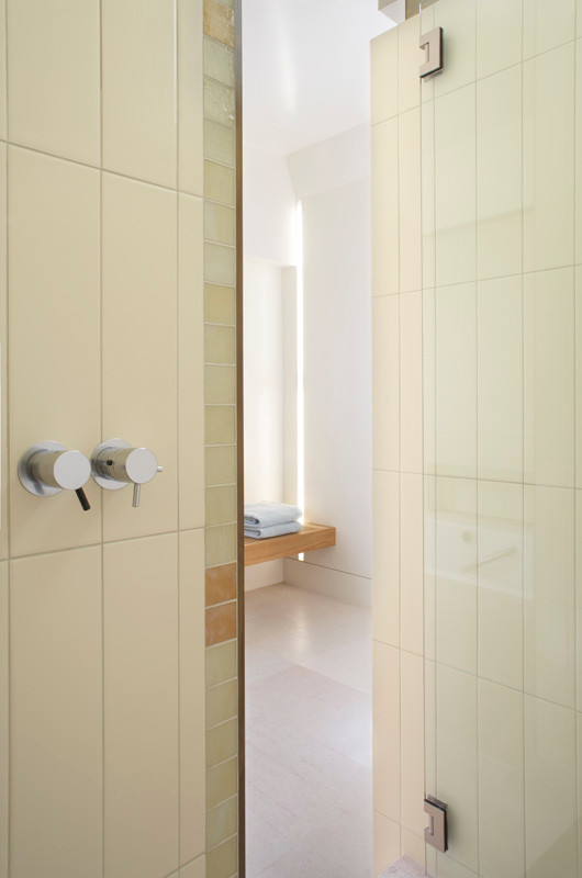 Exemple d'une salle de bain principale moderne avec un placard à porte plane, des portes de placard noires, une baignoire posée, un carrelage multicolore, des carreaux de céramique, un mur multicolore, un sol en carrelage de céramique, un sol beige, aucune cabine et un plan de toilette blanc.
