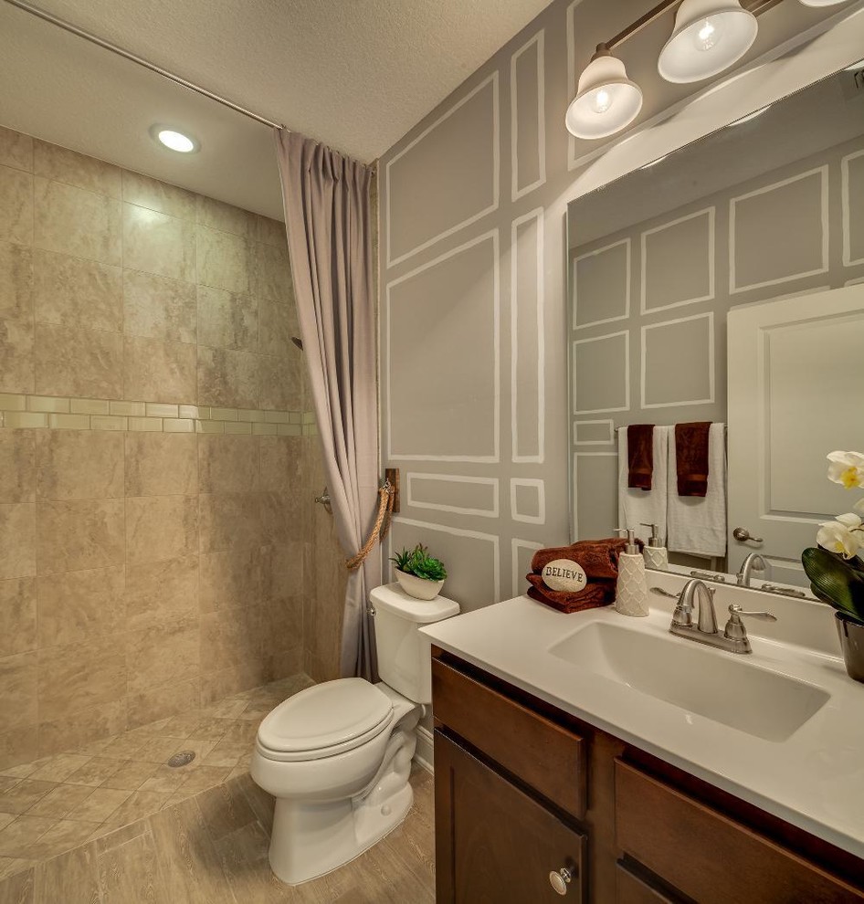 Réalisation d'une salle de bain tradition en bois brun de taille moyenne avec un placard à porte shaker, WC séparés, un mur multicolore, sol en stratifié, un lavabo encastré et un plan de toilette en surface solide.