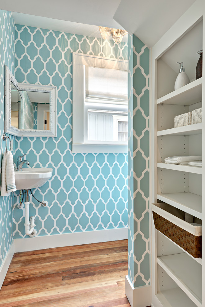 Bild på ett litet vintage badrum, med ett väggmonterat handfat, blå väggar, mellanmörkt trägolv och öppna hyllor