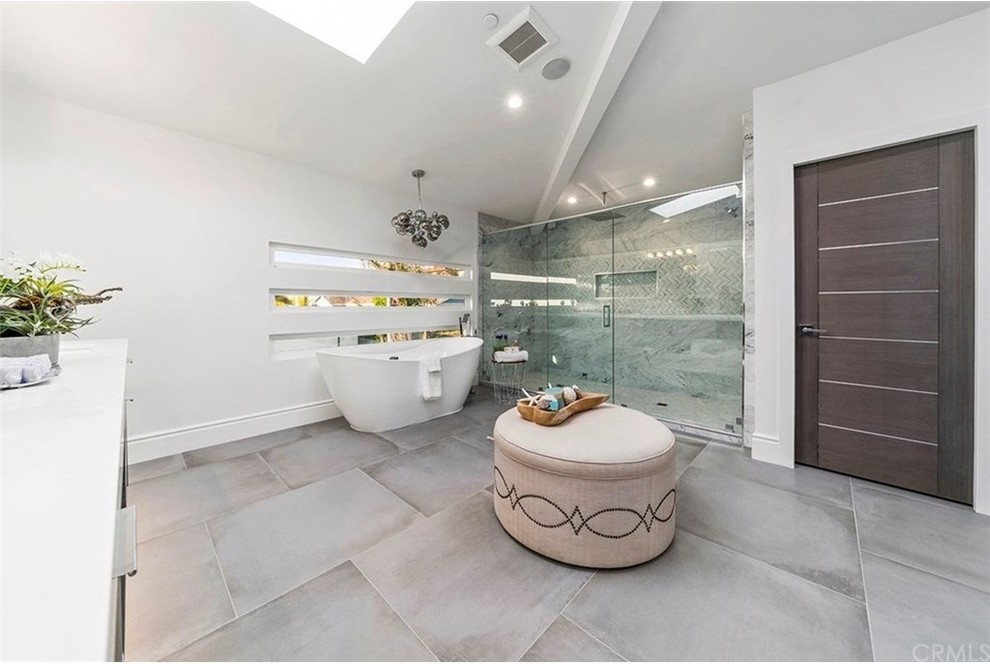 Foto på ett stort funkis vit en-suite badrum, med släta luckor, grå skåp, ett fristående badkar, en öppen dusch, klinkergolv i porslin, bänkskiva i kvarts och grått golv