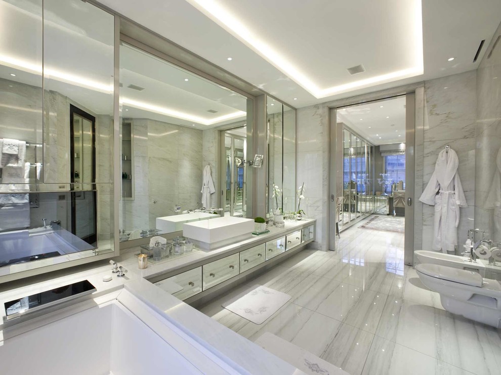 Пример оригинального дизайна: огромная главная ванная комната в стиле неоклассика (современная классика) с настольной раковиной, плоскими фасадами, мраморной столешницей, биде, серой плиткой, серыми стенами, мраморным полом и мраморной плиткой