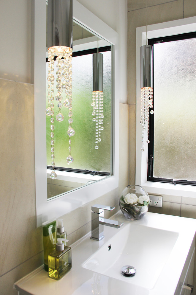 Idées déco pour une salle de bain contemporaine avec un lavabo suspendu, des portes de placard blanches et un carrelage beige.