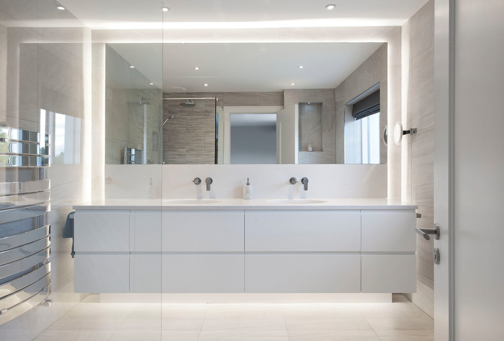 Inredning av ett modernt mellanstort badrum med dusch, med släta luckor, vita skåp, vita väggar, beige kakel, ett undermonterad handfat och beiget golv