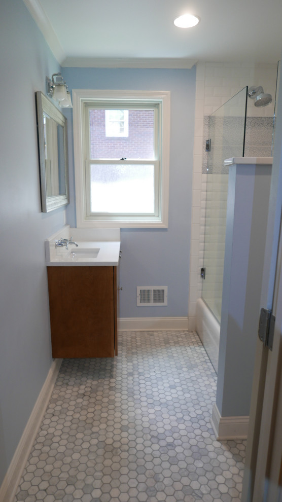Пример оригинального дизайна: детская ванная комната среднего размера в современном стиле с плоскими фасадами, светлыми деревянными фасадами, ванной в нише, душем над ванной, раздельным унитазом, белой плиткой, плиткой кабанчик, синими стенами, полом из мозаичной плитки, врезной раковиной, столешницей из искусственного кварца, разноцветным полом, душем с распашными дверями и белой столешницей