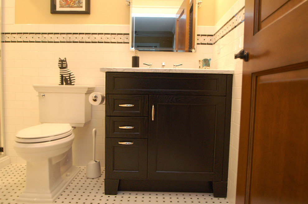 Idée de décoration pour une petite salle de bain tradition avec WC à poser, un carrelage blanc, un carrelage métro, un sol en carrelage de terre cuite, un lavabo encastré, un placard avec porte à panneau encastré, des portes de placard noires, un mur jaune et un plan de toilette en marbre.
