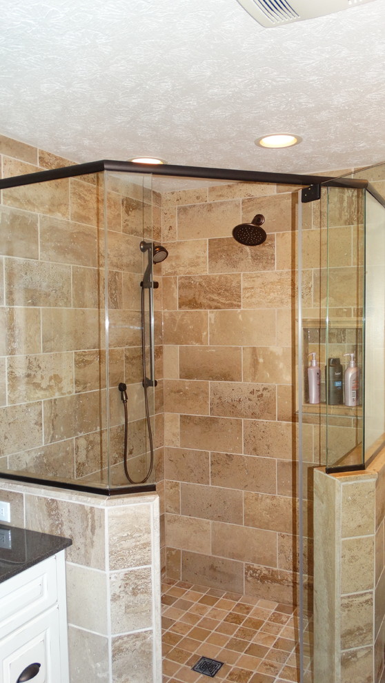 Cette photo montre une salle de bain principale chic en bois vieilli de taille moyenne avec un lavabo encastré, un placard avec porte à panneau surélevé, une baignoire posée, une douche d'angle et un carrelage beige.
