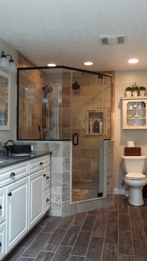 Immagine di una stanza da bagno padronale classica di medie dimensioni con ante con bugna sagomata, doccia ad angolo, parquet scuro, lavabo sottopiano, vasca da incasso, piastrelle marroni e ante bianche