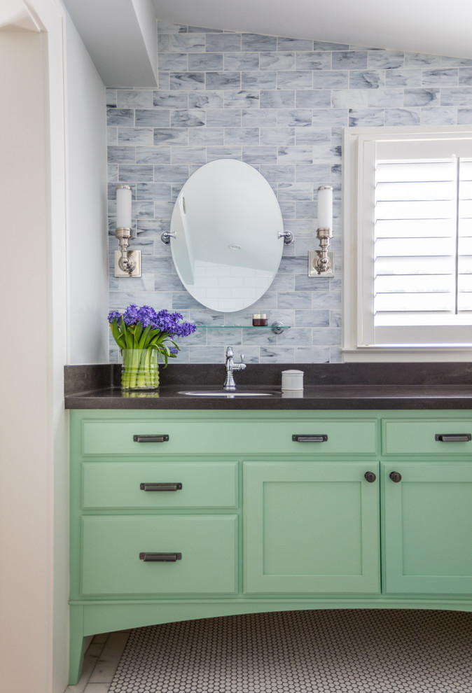 Diseño de cuarto de baño romántico con puertas de armario verdes, baldosas y/o azulejos azules, suelo con mosaicos de baldosas, lavabo bajoencimera, encimeras negras y armarios estilo shaker