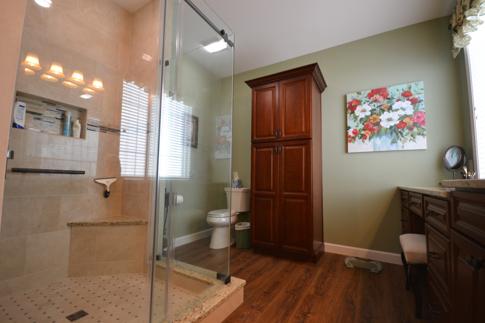 Cette photo montre une grande salle de bain principale chic en bois brun avec un placard avec porte à panneau surélevé, une douche d'angle, WC à poser, un mur vert, un sol en bois brun, un lavabo encastré, un plan de toilette en granite, un sol marron, une cabine de douche à porte coulissante, un plan de toilette beige, une niche, meuble double vasque et meuble-lavabo encastré.