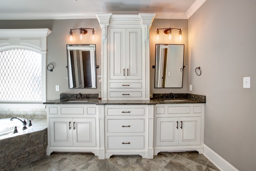 Exemple d'une salle de bain chic avec une baignoire posée, des carreaux de porcelaine, des portes de placard blanches et un plan de toilette en marbre.