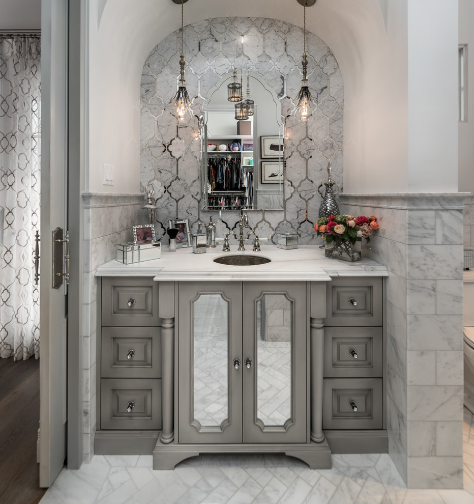 This is an example of an expansive mediterranean ensuite bathroom in Phoenix with freestanding cabinets, grey cabinets, a built-in bath, an alcove shower, a one-piece toilet, multi-coloured tiles, multi-coloured walls, marble flooring, a submerged sink, marble worktops, white floors, a hinged door and multi-coloured worktops.