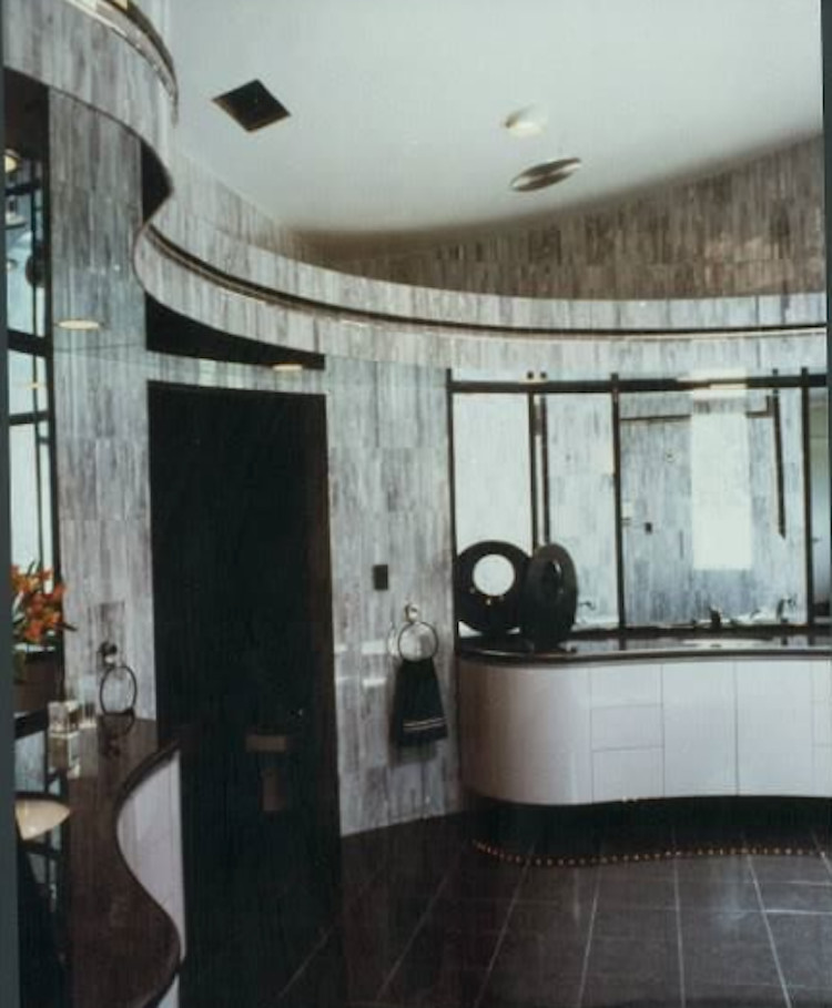 Modelo de cuarto de baño principal actual grande con lavabo bajoencimera, armarios tipo mueble, encimera de granito, bañera encastrada, ducha doble, bidé, baldosas y/o azulejos grises, paredes grises, puertas de armario grises y suelo de mármol