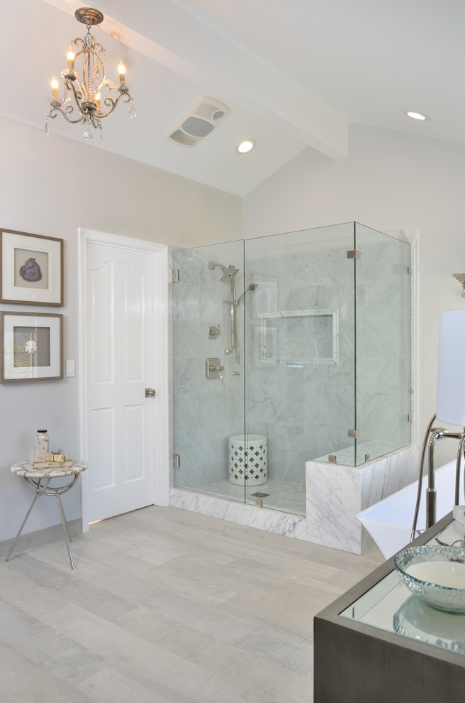 Klassisk inredning av ett stort grå grått en-suite badrum, med möbel-liknande, grå skåp, ett fristående badkar, en hörndusch, en toalettstol med hel cisternkåpa, grå kakel, marmorkakel, grå väggar, klinkergolv i porslin, ett undermonterad handfat, marmorbänkskiva, grått golv och dusch med gångjärnsdörr
