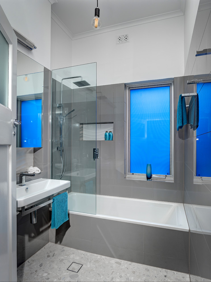 На фото: маленькая главная ванная комната в стиле модернизм с подвесной раковиной, накладной ванной, открытым душем, инсталляцией, серой плиткой, серыми стенами и полом из керамогранита для на участке и в саду с