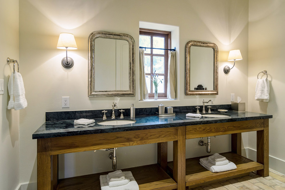 オースティンにあるラスティックスタイルのおしゃれな浴室 (アンダーカウンター洗面器、オープンシェルフ、中間色木目調キャビネット、レンガの床) の写真