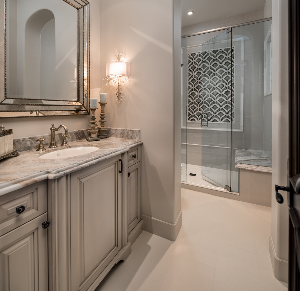 Huge transitional master multicolored tile and mirror tile porcelain tile and beige floor bathroom photo in Phoenix with raised-panel cabinets, beige cabinets, a drop-in sink, granite countertops, a hinged shower door, multicolored countertops, a two-piece toilet and beige walls