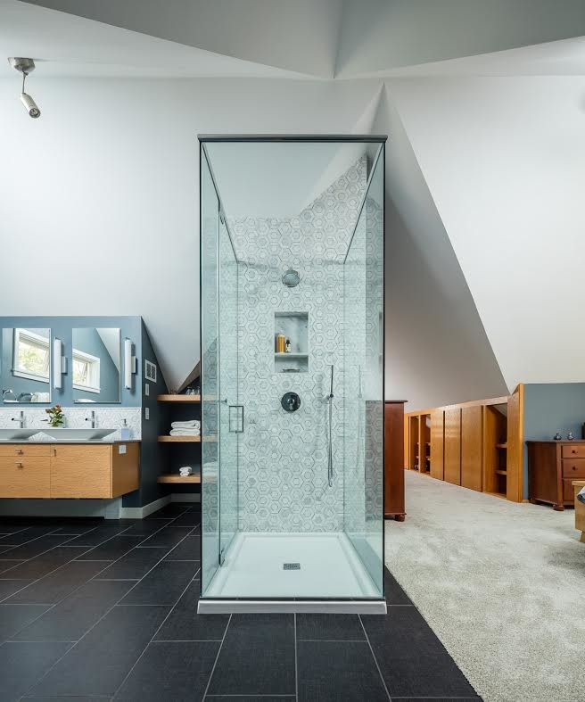 Свежая идея для дизайна: главная ванная комната среднего размера в современном стиле с плоскими фасадами, светлыми деревянными фасадами, отдельно стоящей ванной, душем без бортиков, синими стенами, настольной раковиной и черным полом - отличное фото интерьера