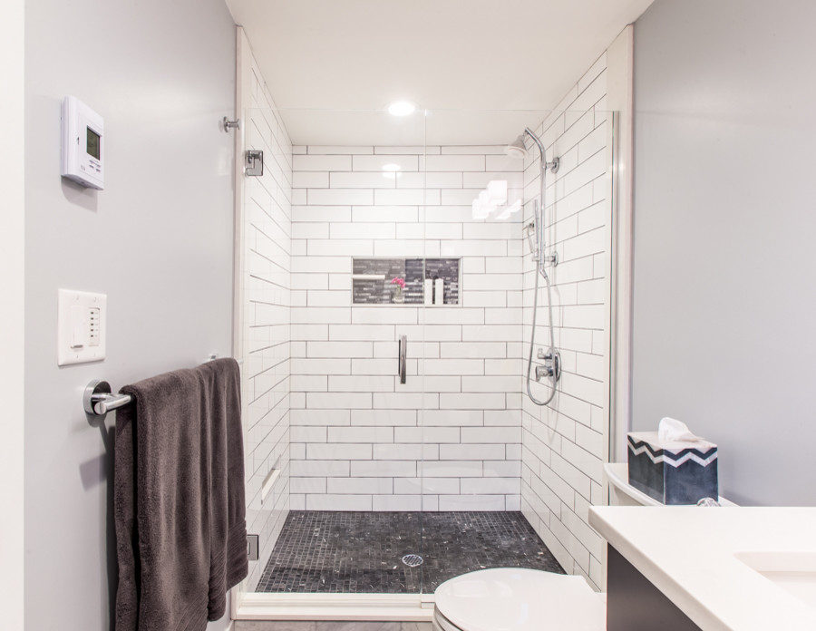 Cette photo montre une salle de bain tendance en bois foncé de taille moyenne avec WC à poser, un carrelage blanc, des carreaux de porcelaine, un mur gris, un lavabo encastré, un placard à porte plane, un sol en marbre et un plan de toilette en quartz modifié.